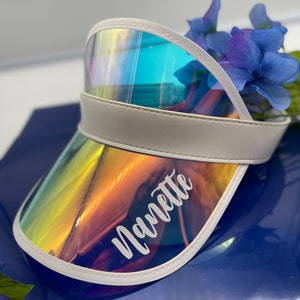 May include: White visor with a rainbow iridescent visor and the name "Navette" written in white on the visor.