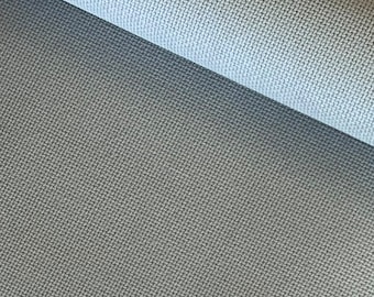 May include: Close-up of a light gray fabric with a subtle woven texture. The fabric is smooth and appears to be soft.