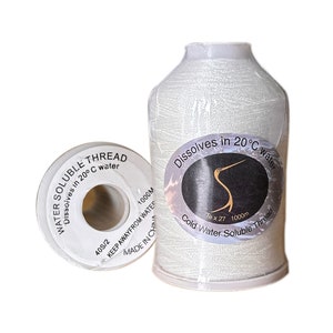 Puede incluir: Dos carretes de hilo soluble en agua de color blanco, cada uno con una etiqueta que dice "Dissolves in 20°C water". La etiqueta del carrete de la izquierda también dice "WATER SOLUBLE THREAD" y "40S/2 1000M KEEP AWAYFROM WATER MADE IN CHINA".