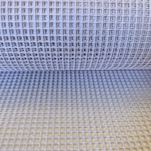 Puede incluir: Una tela de color gris claro que presenta una textura de tejido de gofre. El material se compone de un patr&oacute;n de cuadr&iacute;cula repetitivo de cuadrados elevados, creando una superficie tridimensional con profundidad visible y espaciado constante.