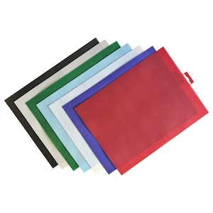 May include: A stack of colorful placemats in various shades, including black, green, light blue, white, blue, and red. Each placemat has a textured surface and a rectangular shape, with a small tab on one corner of the red one.