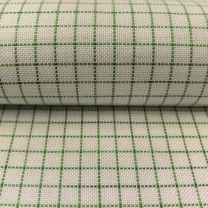 May include: Close-up of a fabric with a grid pattern. The fabric is a light beige colour with a green grid overlay. The grid lines are evenly spaced, creating a classic, structured design. The fabric appears to be woven.