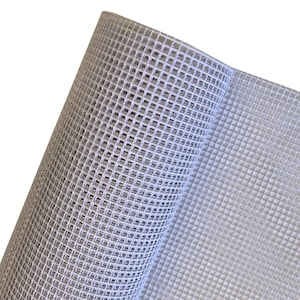 Puede incluir: Un rollo de tela de malla de pl&aacute;stico blanco que presenta un patr&oacute;n de cuadr&iacute;cula consistente con aberturas cuadradas. El material es semirr&iacute;gido y transl&uacute;cido, mostrando una estructura geom&eacute;trica repetitiva en toda la superficie.
