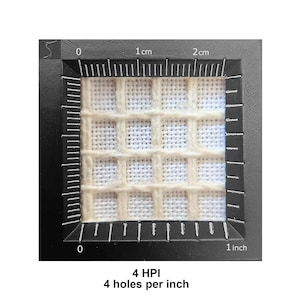 Puede incluir: Una pieza cuadrada de lienzo de pl&aacute;stico color hueso con un patr&oacute;n de cuadr&iacute;cula, enmarcada por una herramienta de medici&oacute;n negra que muestra 2,54 cm de ancho. El texto inferior indica 4 HPI y 4 agujeros por pulgada de densidad.