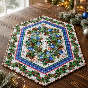 Peut inclure: Un chemin de table hexagonal en tissu avec un imprimé festif. Le motif présente une couronne centrale de branches de pin, de pommes de pin, de baies rouges et d'ornements bleus et argentés, encadrée par une bordure à carreaux bleu et vert.