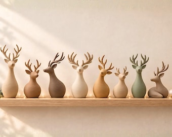 Puede incluir: Un conjunto de ocho figuras de renos en varios tonos beige, marrón y verde salvia, con cuerpos lisos y redondeados y astas detalladas. El texto "Minimalist Christmas Reindeer Set - 8 Model 3D STL FILES" aparece sobre las figuras.
