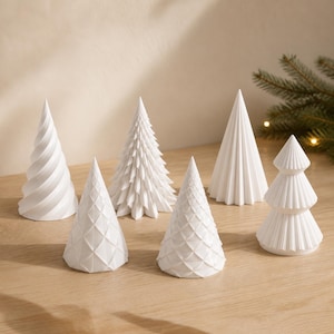 Puede incluir: Una colecci&oacute;n de seis adornos decorativos blancos en forma de cono, cada uno con una textura distinta que incluye patrones en espiral, de diamante, plisados y en capas. Estos objetos esculturales est&aacute;n dispuestos en grupo.