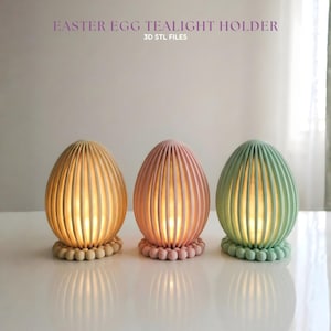 Op de afbeelding: Drie pastelkleurige paasei-theelichthouders. De eivormige houders zijn geribbeld en staan op een kralenvoet. De tekst "EASTER EGG TEALIGHT HOLDER" en "3D STL FILES" staat boven de eieren.