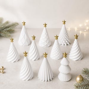 Puede incluir: Una colecci&oacute;n de diez adornos navide&ntilde;os c&oacute;nicos de color blanco, cada uno rematado con una peque&ntilde;a estrella dorada. Los &aacute;rboles presentan diversas texturas, incluyendo espirales lisas, facetas geom&eacute;tricas y crestas escalonadas.