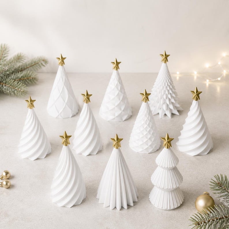 Puede incluir: Una colecci&oacute;n de diez adornos navide&ntilde;os c&oacute;nicos de color blanco, cada uno rematado con una peque&ntilde;a estrella dorada. Los &aacute;rboles presentan diversas texturas, incluyendo espirales lisas, facetas geom&eacute;tricas y crestas escalonadas.