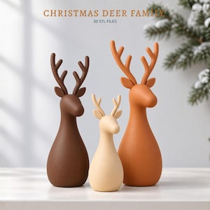 Puede incluir: Tres figuras de ciervos estilizadas de diferentes tamaños y colores, incluyendo marrón oscuro, crema y naranja claro. Cada ciervo presenta cuerpos lisos y redondeados con astas ramificadas. El texto CHRISTMAS DEER FAMILY 3D STL FILES es visible.