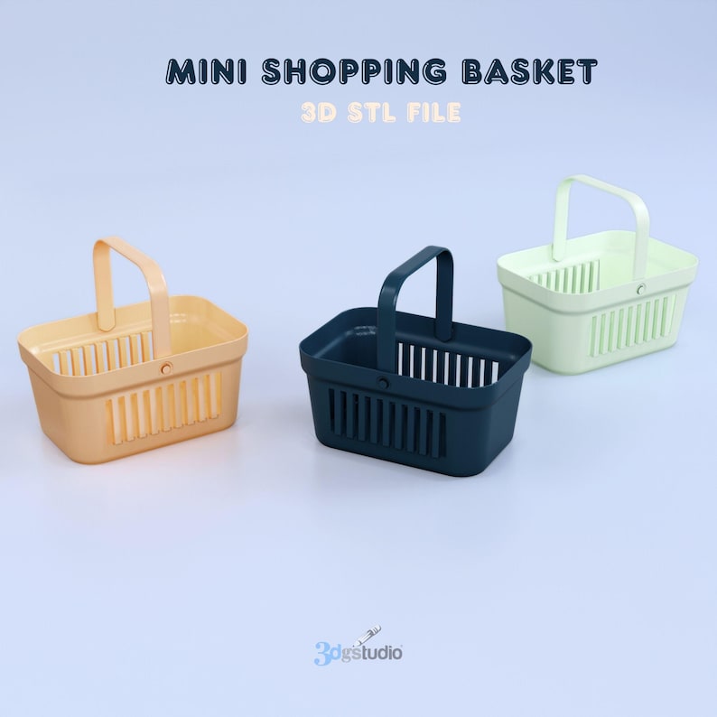 May include: Three mini shopping baskets in different colors: peach, navy blue, and light green. Each basket has a rectangular shape with vertical slats and a handle. The text "MINI SHOPPING BASKET" and "3D STL FILE" are at the top.