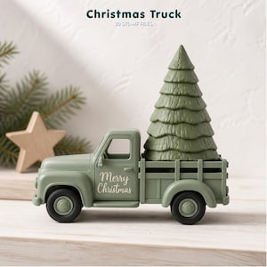 Op de afbeelding: Een saliegroene speelgoedtruck met een gestructureerde groene dennenboom in de laadbak. Op de zijkant van de truck staat de witte tekst Merry Christmas. De truck heeft zwarte wielen en een matte afwerking als decoratief object.