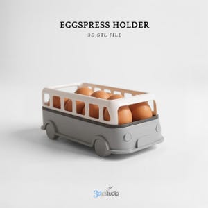 May include: A gray and white egg holder shaped like a bus, filled with brown eggs. The text "EGGSPRESS HOLDER" and "3D STL FILE" are printed at the top. The logo "3dgsudio" is at the bottom.