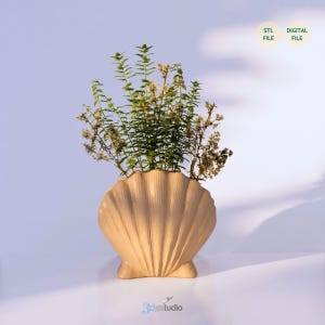 Puede incluir: Un jarrón beige en forma de concha lleno de plantas verdes y secas. El jarrón tiene una superficie texturizada y está sobre una superficie blanca. El texto "STL FILE" y "DIGITAL FILE" está en la esquina superior derecha.
