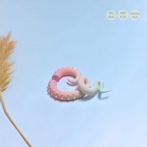 May include: A pink and white ombre 3D printed octopus tentacle with white dots and a green and white ombre tentacle. The tentacles are on a white background. STL, 3MF, DIGITAL FILE.