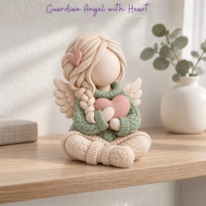May include: A figurine of a faceless angel with blonde hair in a side braid, wearing a sage green cable-knit sweater and matching pants. The angel has small wings, holds a pink heart, and features a small pink heart in its hair.