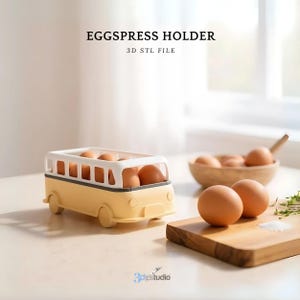 May include: A yellow and white egg holder shaped like a bus, filled with brown eggs. The text "EGGSPRESS HOLDER" and "3D STL FILE" are displayed above the bus. A wooden bowl and cutting board with eggs are also visible.