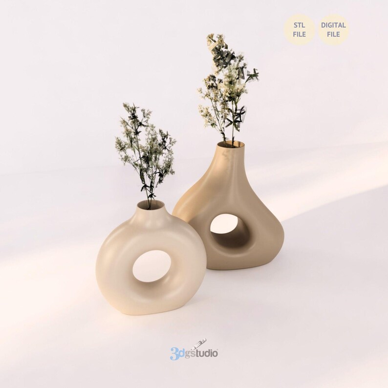 K&ouml;nnte beinhalten: Zwei beige Keramikvasen mit Trockenblumen. Eine Vase ist rund mit einer kreisf&ouml;rmigen &Ouml;ffnung, die andere tropfenf&ouml;rmig mit einem gro&szlig;en Loch. Der Text "STL FILE" und "DIGITAL FILE" ist ebenfalls vorhanden.