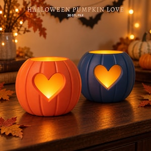 May include: Two pumpkin-shaped candle holders, one orange and one blue, each featuring a heart-shaped cutout on the front. The text HALLOWEEN PUMPKIN LOVE 3D STL FILE is visible at the top. The holders emit a warm, glowing light from within.
