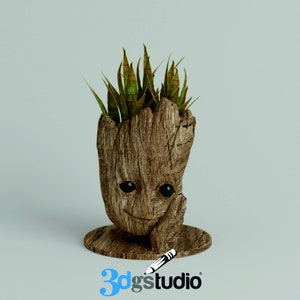 May include: A wooden planter shaped like the character Groot from the Guardians of the Galaxy movie. The planter has a smiling face and is holding a plant with green leaves.