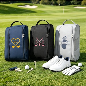 May include: Three golf shoe bags in navy blue, black, and light gray, each with a top handle and zipper. The navy bag features a yellow heart and golf clubs with initials BG. The black bag has pink initials SH and golf clubs. The gray bag displays a golf bag graphic with the name Grace.
