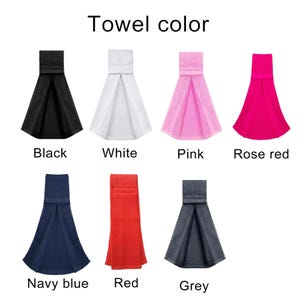 May include: A collection of seven hanging kitchen towels displayed in a grid with the text Towel color at the top. The towels are available in black, white, pink, rose red, navy blue, red, and grey, each featuring a folded top tab design.