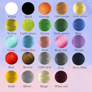 Op de afbeelding: Kleurenkaart met borduurgarenopties. De kaart toont een verscheidenheid aan kleuren, waaronder wit, zwart, oranje, geel, groen, blauw, roze, rood, bruin, grijs, goud, zilver, beige en bordeauxrood. De tekst luidt 'Borduurkleuropties'.