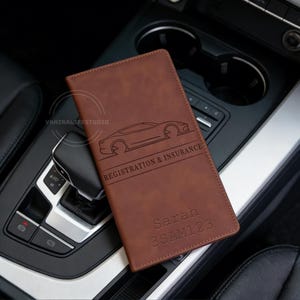 May include: Brown leather registration and insurance holder with a car outline and the text "REGISTRATION & INSURANCE". The holder is personalized with the name "Sarah" and license plate "3SAM123".