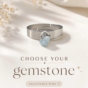 Könnte beinhalten: Verstellbarer Silberring mit herzförmigem, hellblauem Edelsteinanhänger. Das Bild enthält den Text "CHOOSE YOUR gemstone" und "ADJUSTABLE RING". Der Ring wird auf einer weißen Oberfläche präsentiert.