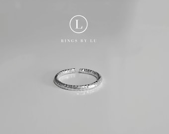 May include: A silver hammered ring with a textured finish. Rings By Lu.
