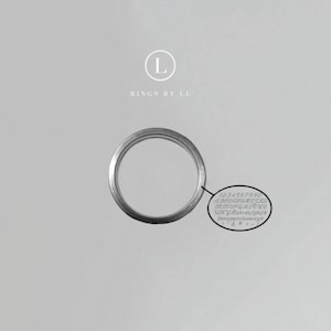 Può includere: Un anello d'argento con una finitura semplice e lucida. L'anello è mostrato su uno sfondo bianco con il testo "Rings by Lu" e la lettera "L" in un cerchio.