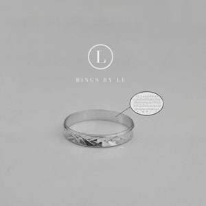 Puede incluir: Un anillo de banda de plata con un patr&oacute;n de diamante. El anillo est&aacute; grabado con el texto "RINGS BY LU".