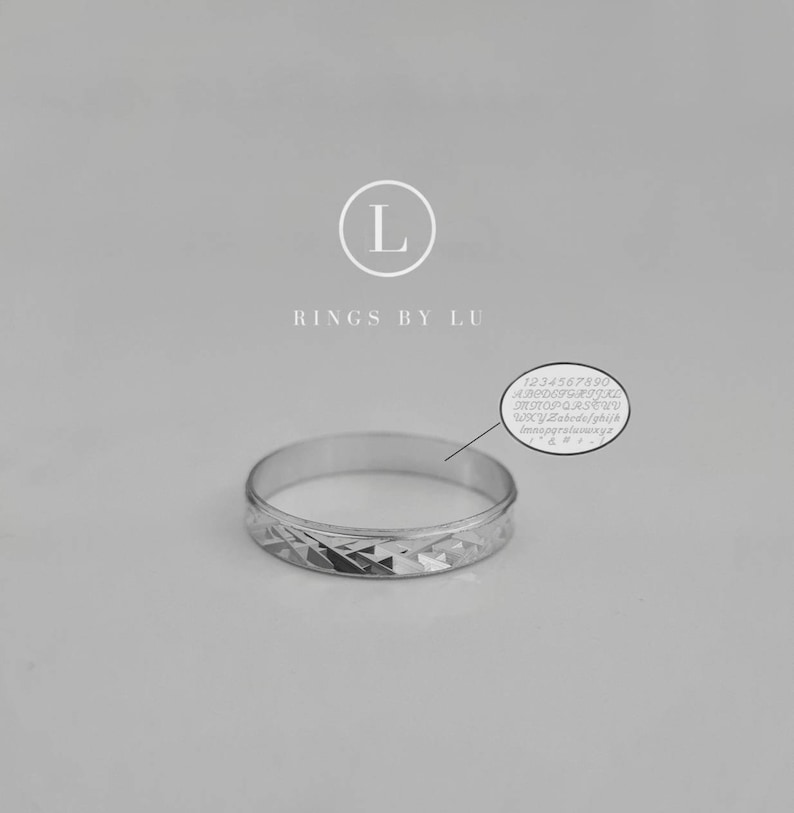 Puede incluir: Un anillo de banda de plata con un patr&oacute;n de diamante. El anillo est&aacute; grabado con el texto "RINGS BY LU".