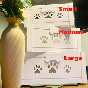 May include: Three white wooden dog crates stacked on top of each other. The crates are labeled "Small", "Medium", and "Large". Each crate has a bone-shaped handle and paw print cutouts.