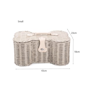 May include: A small bone-shaped wicker basket with a light beige finish, featuring a top handle and a central latch closure. The basket measures 43 cm in length, 23 cm in width, and 18 cm in height, providing a structured storage solution.