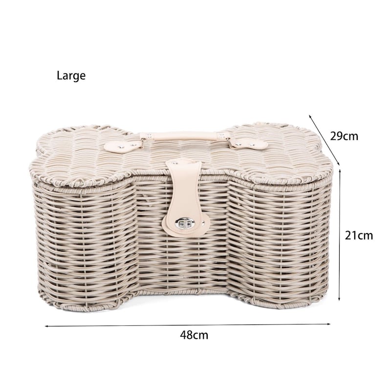 May include: A large bone-shaped wicker basket with a light beige finish, featuring a top handle and a central latch closure. The basket includes dimensions printed on the image, showing a width of 48 cm, a depth of 29 cm, and a height of 21 cm.
