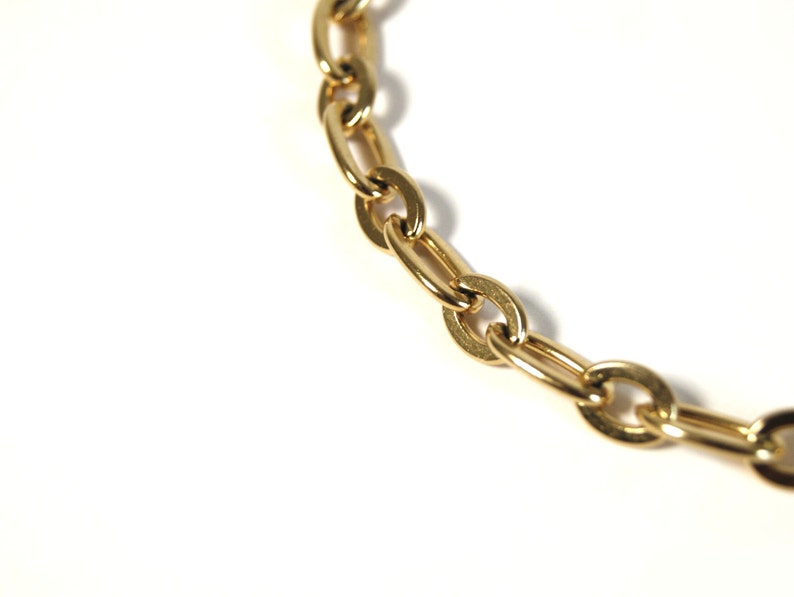 K&ouml;nnte beinhalten: Eine goldene Kettenkette mit ovalen Gliedern.