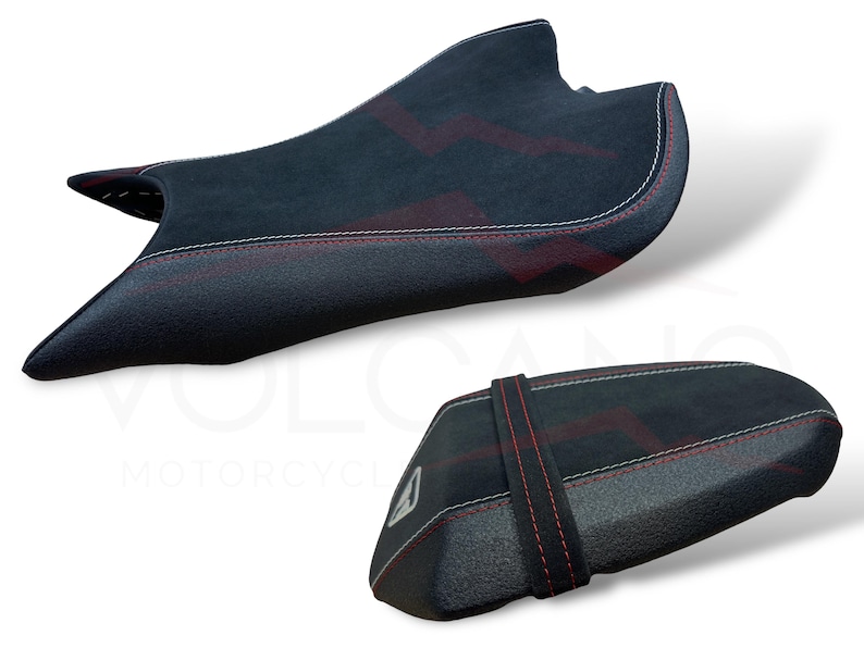 Puede incluir: Dos asientos de moto negros con dise&ntilde;os de rayos rojos y costuras blancas. Uno es m&aacute;s grande y contorneado, el otro m&aacute;s peque&ntilde;o y rectangular con una correa. Probablemente mejoras del mercado de accesorios.