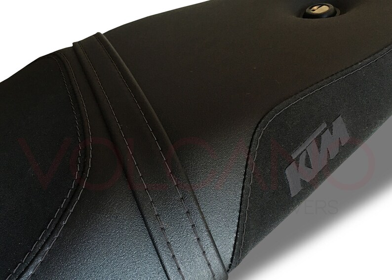 Puede incluir: Asiento de moto negro con un dise&ntilde;o cosido y un logotipo de KTM.