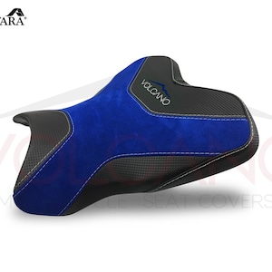 May include: Blue and black motorcycle seat cover with the word "VOLCANO" embroidered on it. The seat cover is made of Alcantara fabric.