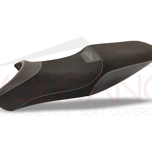 May include: Black motorcycle seat cover with grey accents and the word "Volcano" embossed on the top.