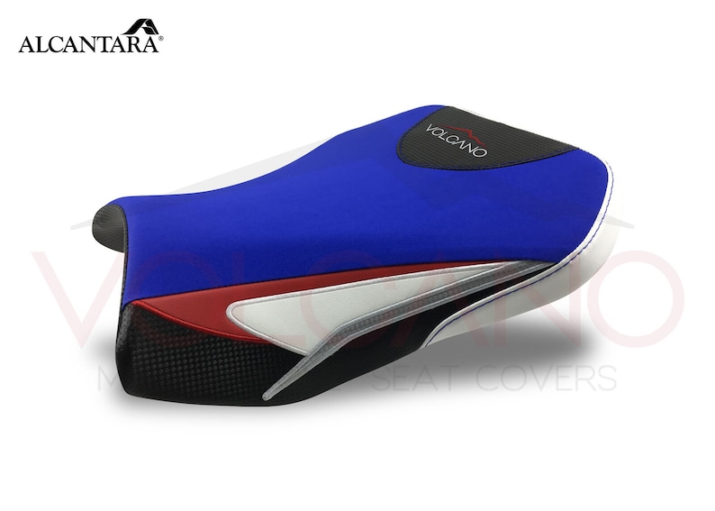 May include: A blue, white and black motorcycle seat cover with the word "VOLCANO" printed on it. The seat cover is made of Alcantara fabric.