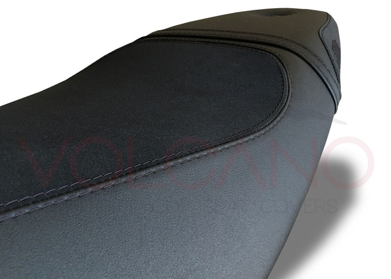 Puede incluir: Asiento de motocicleta negro con una superficie texturizada y una costura.