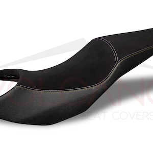 May include: Black motorcycle seat cover with yellow stitching. The seat cover is made of a soft, durable material and is designed to provide a comfortable ride.