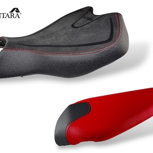 May include: Two motorcycle seats. The top seat is black with red stitching and a textured surface. The bottom seat is red with a black accent. The Alcantara logo is in the top left corner.