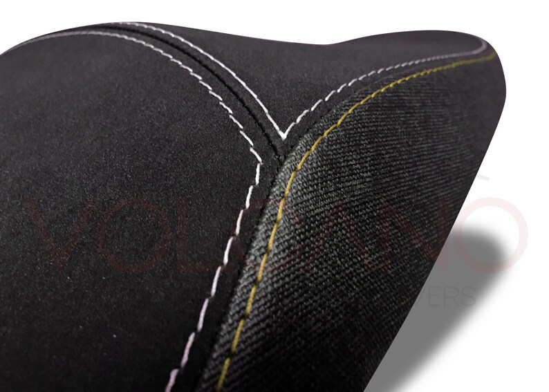 May include: Black motorcycle seat with white and yellow stitching.