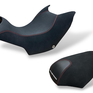 May include: Two-piece motorcycle seat set. The seats are black with red stitching. The top seat has a textured center panel. The bottom seat has the word "MULTISTRADA" printed on it.