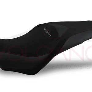 May include: Black motorcycle seat cover with red stitching and the word "VOLCANO" embroidered on the top.