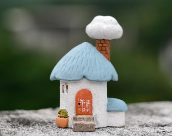 Mini-kleihuis in Scandinavische stijl. Handgemaakte woondecoratie: huisje met blauw dak en wolkenschoorsteen